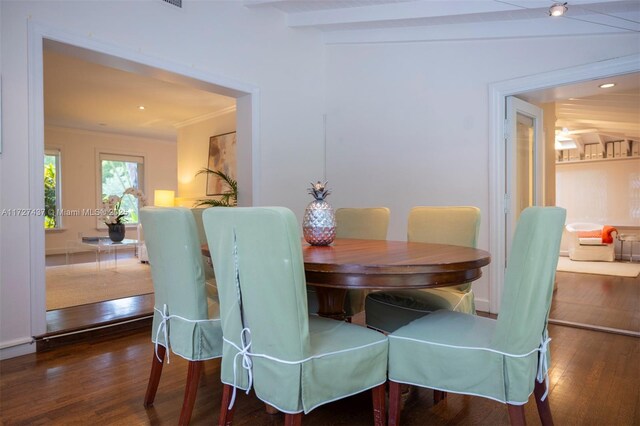 dining room featuring vaulted ceiling, dark hardwood / wood-style flooring, and ornamental molding