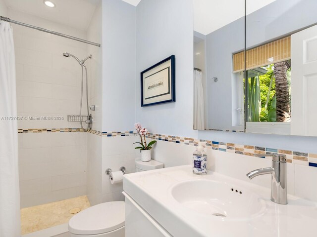 bathroom with toilet, a shower with shower curtain, and vanity