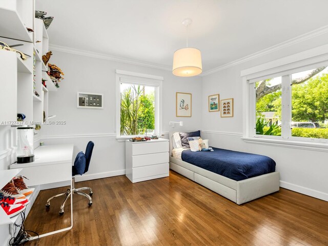 bedroom with dark wood-type flooring, crown molding, and multiple windows