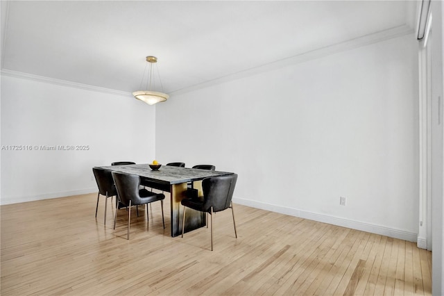 dining area featuring light wood-type flooring and ornamental molding