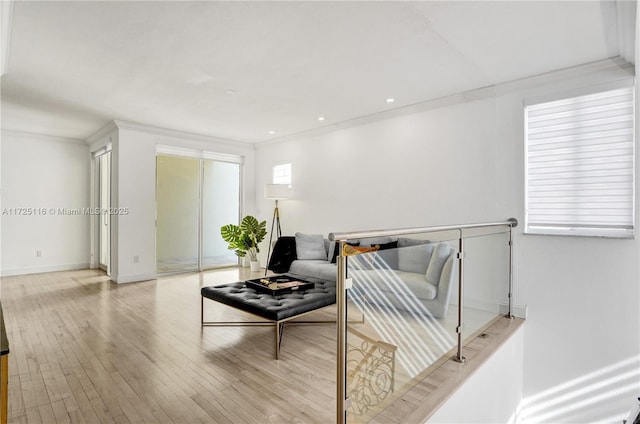 living room with light wood-type flooring and ornamental molding