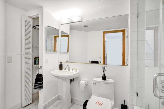 bathroom featuring tile patterned floors, a tile shower, and toilet