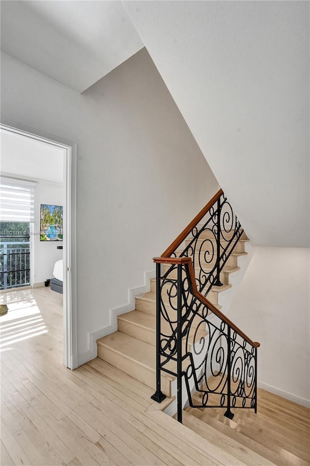 staircase with hardwood / wood-style floors