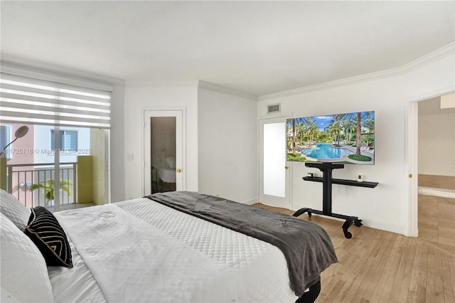 bedroom featuring crown molding, light hardwood / wood-style flooring, and ensuite bath