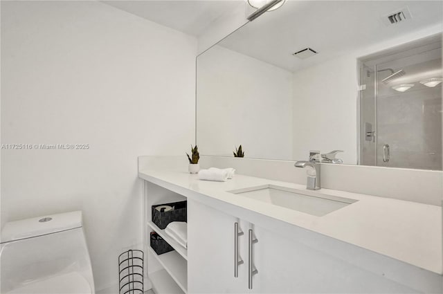 bathroom featuring a shower with shower door, toilet, and vanity