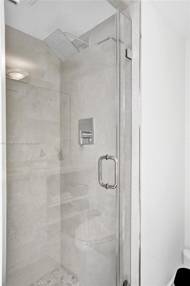 bathroom with toilet and a shower with shower door