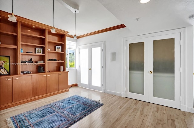 interior space featuring light hardwood / wood-style flooring, crown molding, and french doors