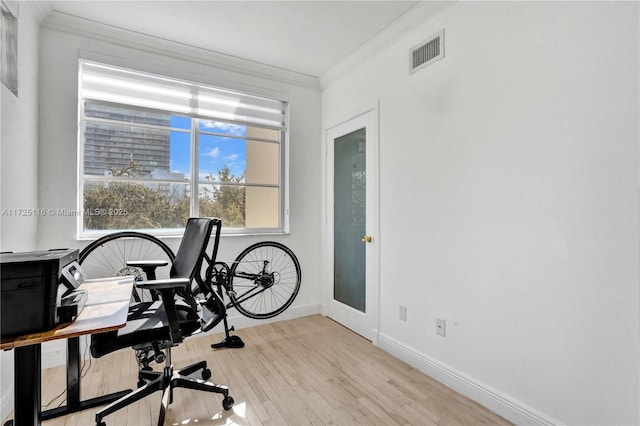 office space featuring light wood-type flooring and ornamental molding