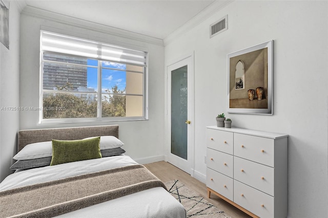 bedroom featuring light wood-type flooring and ornamental molding