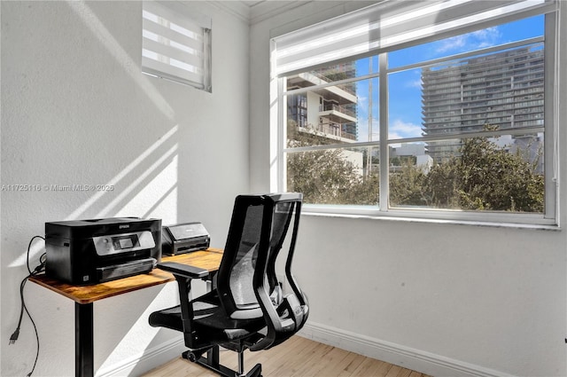 home office featuring crown molding and light hardwood / wood-style floors