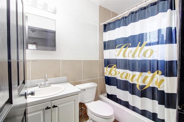 full bathroom with shower / bath combo with shower curtain, tile walls, toilet, and vanity