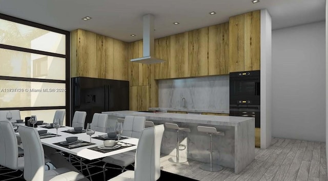 dining space with sink, expansive windows, and light wood-type flooring