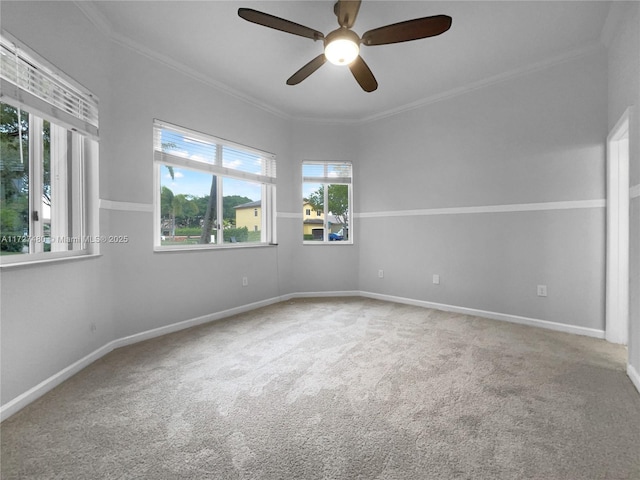 carpeted spare room featuring ceiling fan, a wealth of natural light, and crown molding