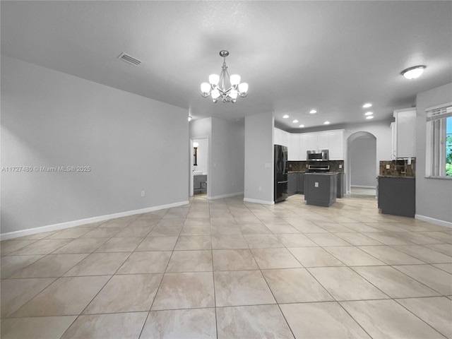 unfurnished living room with light tile patterned floors and a notable chandelier