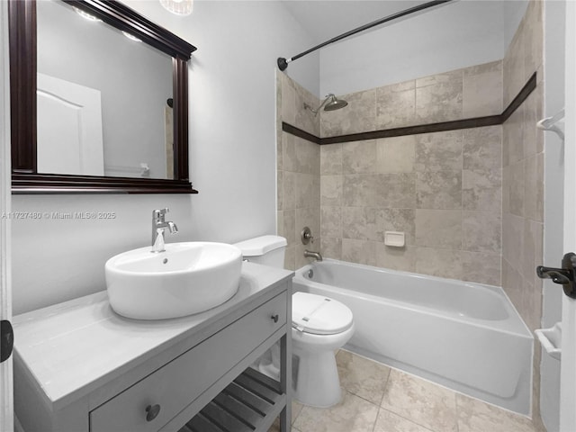 full bathroom featuring tile patterned floors, tiled shower / bath combo, vanity, and toilet