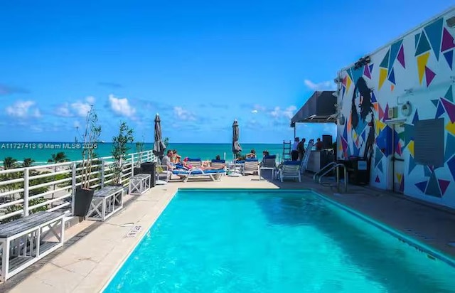 view of swimming pool with a water view