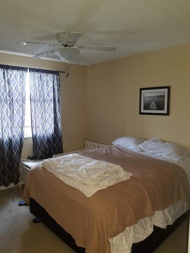 carpeted bedroom with ceiling fan and a textured ceiling