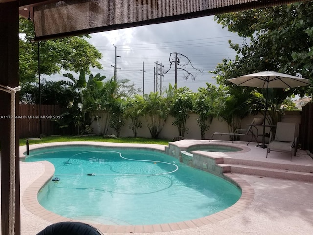 view of pool with an in ground hot tub