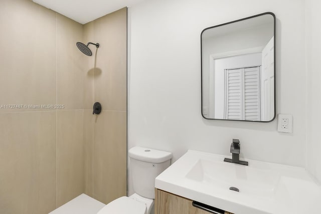 bathroom featuring a shower, toilet, and vanity