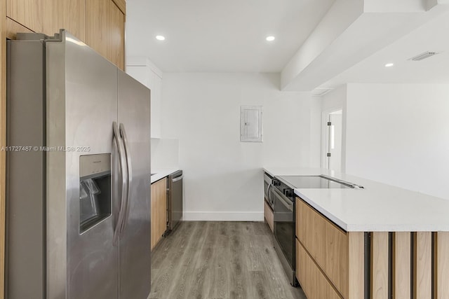 kitchen featuring appliances with stainless steel finishes, electric panel, and light hardwood / wood-style floors