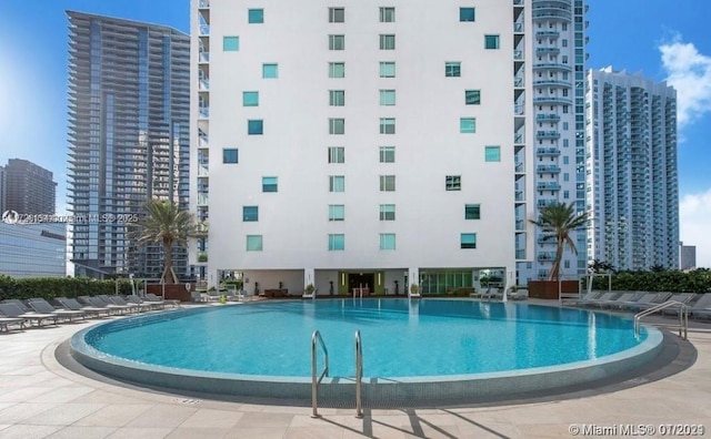 community pool with a view of city and a patio