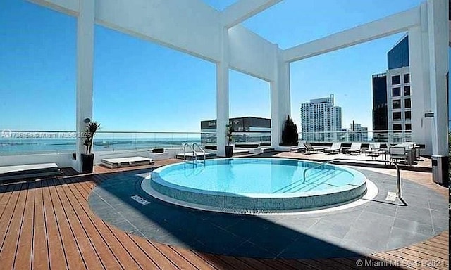 view of swimming pool featuring a water view and a view of city