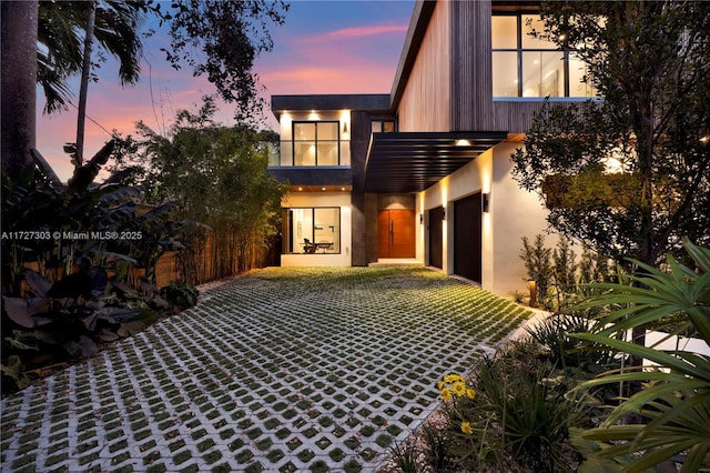 back house at dusk with a garage