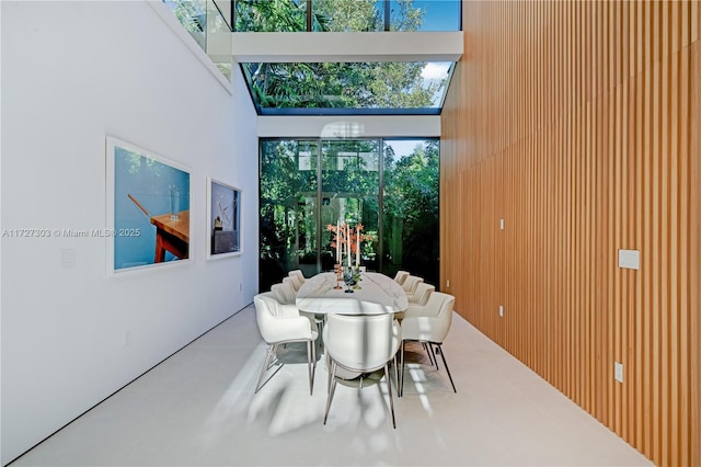 dining area with a healthy amount of sunlight and a towering ceiling