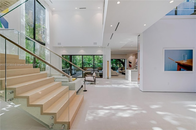 stairway featuring a towering ceiling