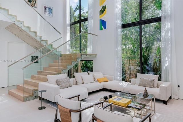 living room featuring a towering ceiling and plenty of natural light