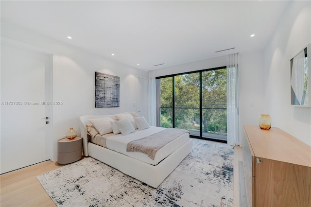 bedroom with access to exterior and light hardwood / wood-style flooring