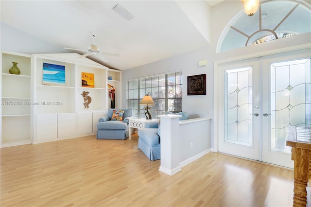 interior space with lofted ceiling, ceiling fan, french doors, and light hardwood / wood-style floors