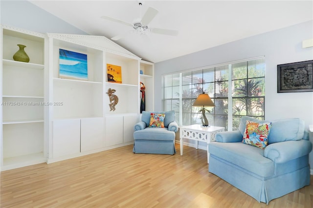 sitting room featuring vaulted ceiling, ceiling fan, hardwood / wood-style flooring, and built in shelves