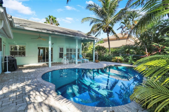 view of pool with ceiling fan and a patio