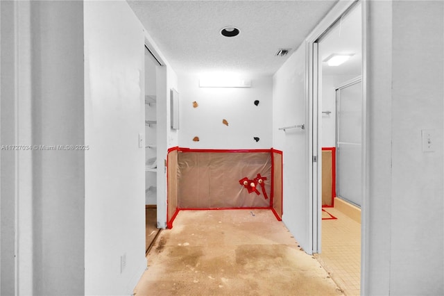 hallway with a textured ceiling