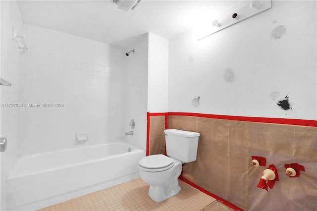 bathroom with toilet, tile patterned flooring, and shower / washtub combination