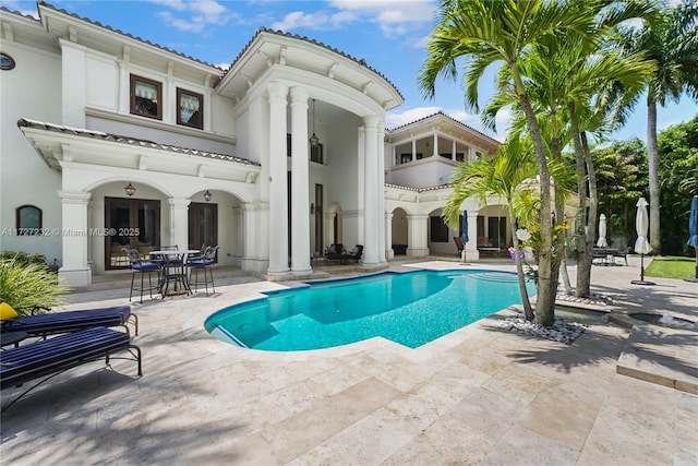 back of house with a patio, an outdoor pool, and stucco siding