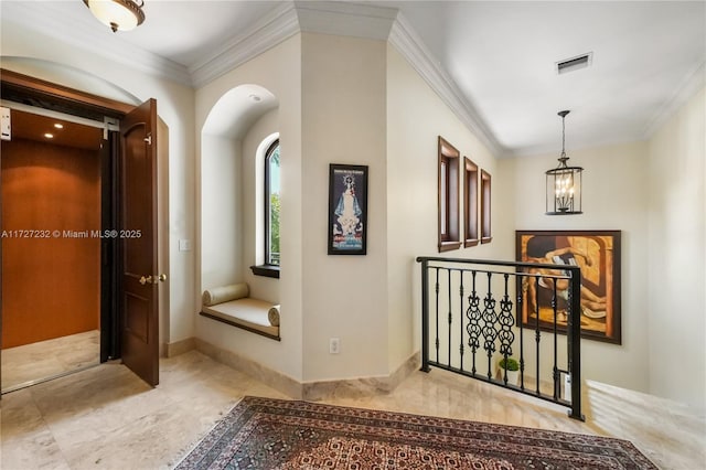 corridor with ornamental molding and a notable chandelier