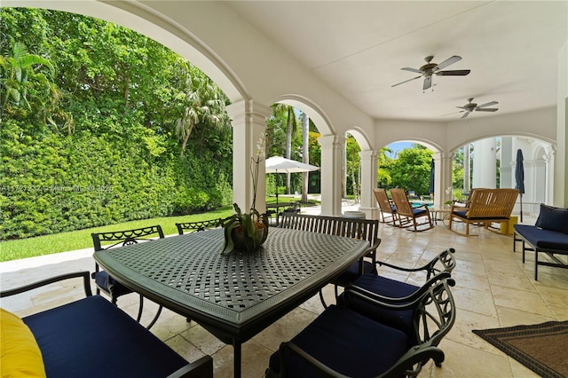 view of patio with outdoor dining area and a ceiling fan