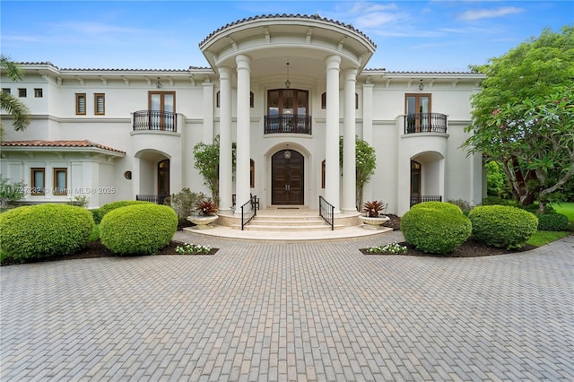 view of front of home featuring a balcony and french doors