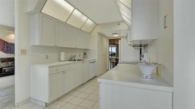 kitchen with sink, light tile patterned floors, white dishwasher, a textured ceiling, and white cabinets