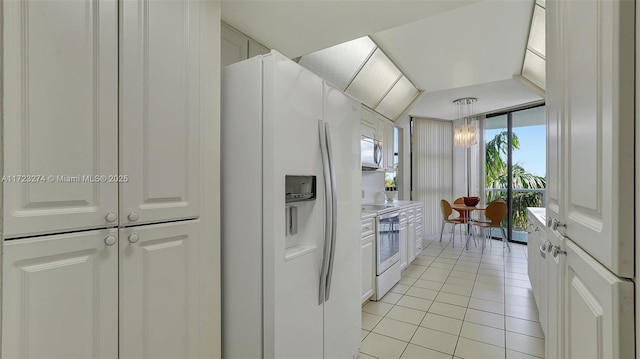 kitchen featuring decorative light fixtures, light countertops, light tile patterned floors, white cabinets, and white appliances
