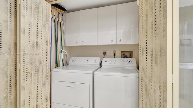 washroom with cabinets and washing machine and clothes dryer