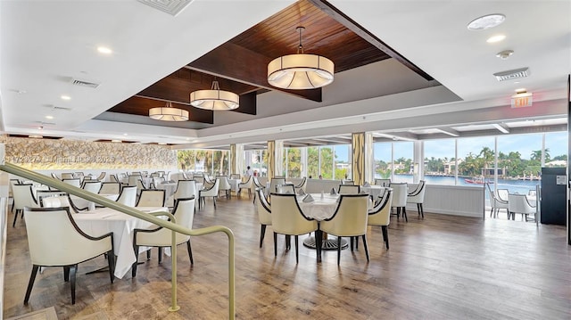 dining space featuring wood ceiling, visible vents, a tray ceiling, and wood finished floors