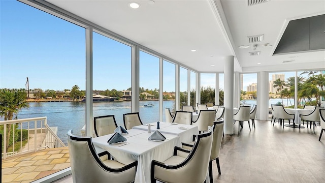 sunroom / solarium with a wealth of natural light, a water view, and visible vents