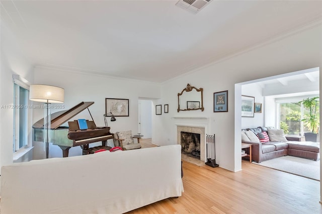 living room featuring crown molding, a high end fireplace, and wood-type flooring