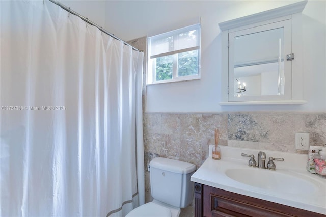 bathroom featuring vanity, tile walls, and toilet