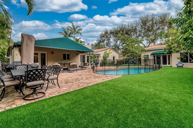 view of swimming pool with a patio, a lawn, and french doors