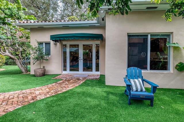 rear view of house with a yard and french doors