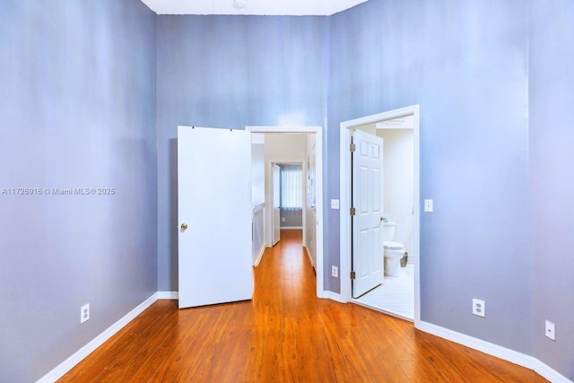 empty room featuring wood finished floors and baseboards